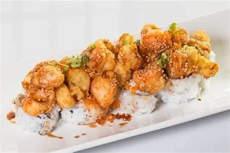 Sushi roll topped with tempura shrimp, drizzled with sauce, and garnished with green onions at Sushi Heaven, a Japanese restaurant in Saratoga
