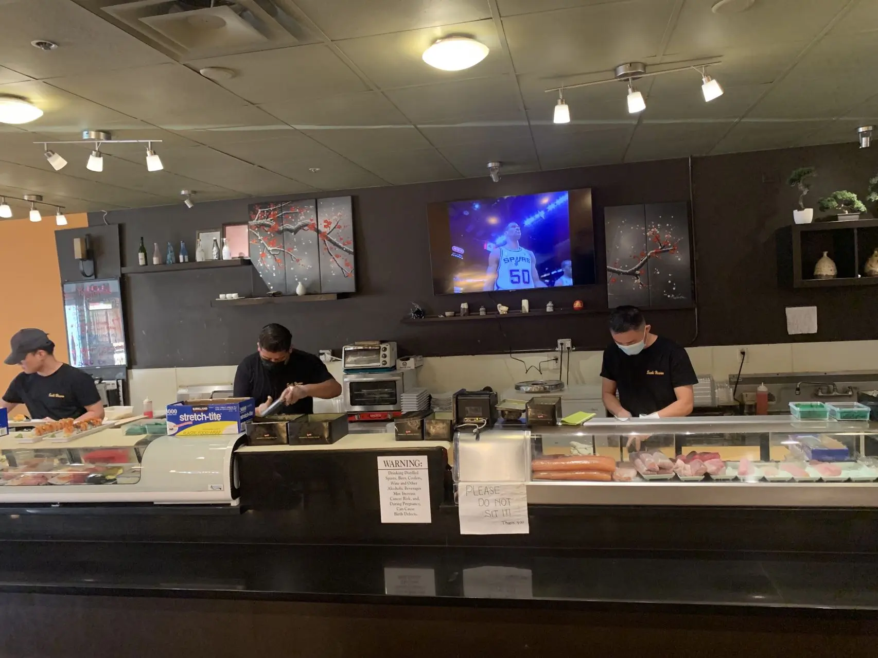 Sushi-Heaven-Japanese-restaurant-Sushi-Bar-Scene-Saratoga Interior of a sushi restaurant with chefs preparing food at the counter at Sushi Heaven, a Japanese restaurant in Saratoga